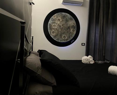 a bedroom with a bed and a moon mural on the wall at Syràkousai Prestige in Syracuse