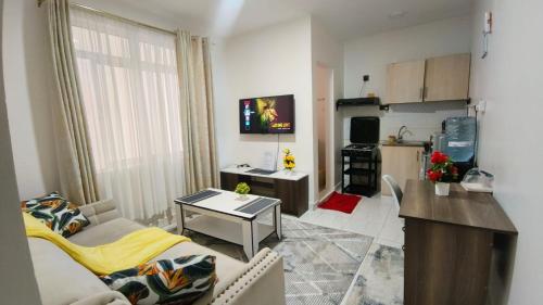 a small living room with a couch and a kitchen at Kiambu road Green Zone Macedonia in Kiambu