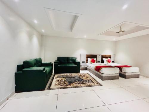 a bedroom with a bed and a couch and chairs at Hotel Kamakhya Inn in Chhatarpur