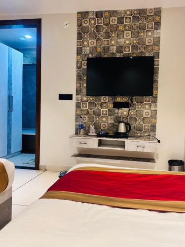 a bedroom with a flat screen tv on a wall at Hotel Kamakhya Inn in Chhatarpur