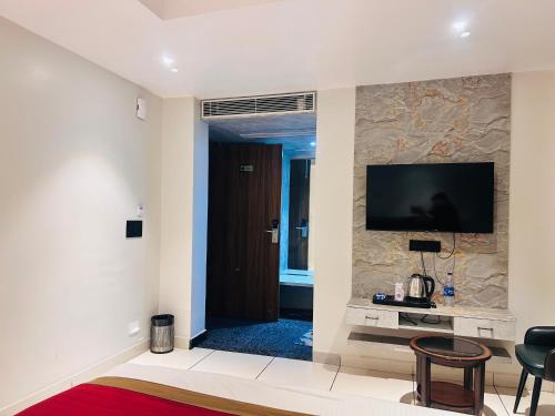 a living room with a flat screen tv on a wall at Hotel Kamakhya Inn in Chhatarpur