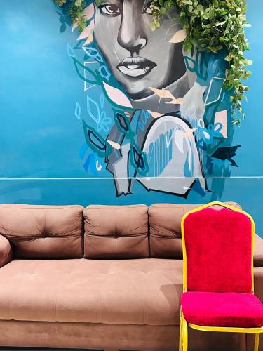 a couch in front of a mural of a woman at Hotel Kamakhya Inn in Chhatarpur