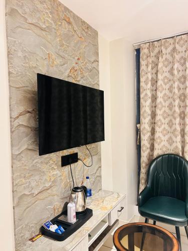 a room with a chair and a television on a wall at Hotel Kamakhya Inn in Chhatarpur