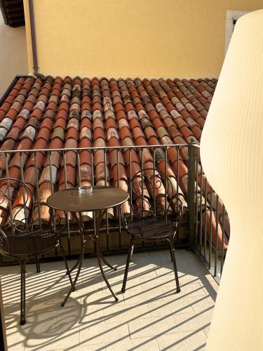 a table and chairs on a balcony with a roof at Ginevra Boutique Rooms - Palazzo Leosini - Residenze D'Epoca in LʼAquila