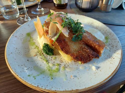 a white plate with food on a table at Breanäs Hotell in Immeln