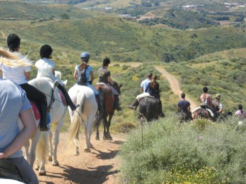 a group of people riding horses on a dirt road at Villa con Jacuzzi exterior y Piscina cubiertos in Los Ángeles de San Rafael