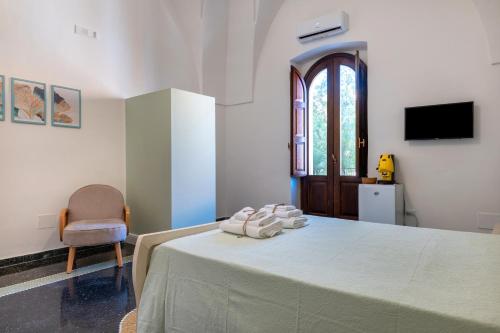 a bedroom with a bed with a chair and a window at Gma Home Primo Piano in Pulsano