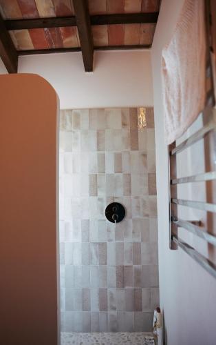 a bathroom with a shower with a tiled wall at Beautiful villa with private pool and mountain views in Jimena de la Frontera