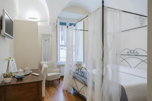 a bedroom with a canopy bed with a desk and a chair at B&B Quattro Cantoni in Siena