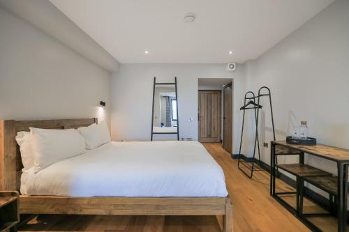 a bedroom with a large white bed and a desk at Oban Bay Apartments in Oban