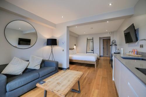 a living room with a blue couch and a bedroom at Oban Bay Apartments in Oban
