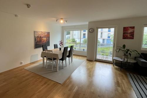 a dining room and living room with a table and chairs at 83m2-3 sleeping rooms-2 balconies-direct traffic to airport and tourist places in Bergen