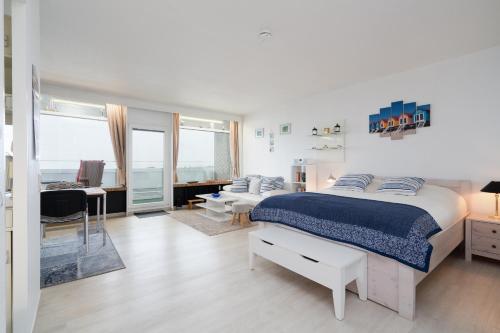 a white bedroom with a bed and a living room at Panoramic App B08-6 in Sierksdorf