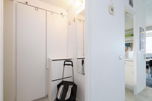 a kitchen with white cabinets and a black bag at Panoramic App B08-6 in Sierksdorf