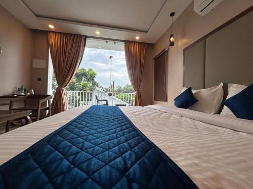a bedroom with a large bed and a balcony at AuroBESHA in Puducherry Airpoert