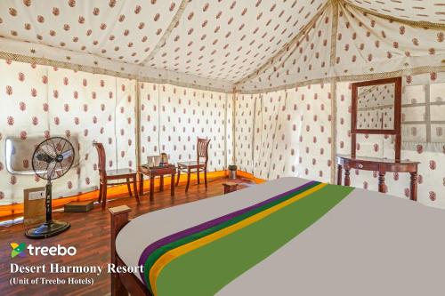 a bedroom with a bed and chairs in a room at Treebo Desert Harmony Camp in Sām