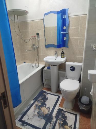 a bathroom with a toilet and a tub and a sink at Квартира in Taraz