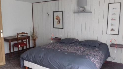 a bedroom with a bed and a table and a desk at La Gentilhommière - Chambre avec sauna et jaccuzzi in Saint-Roch