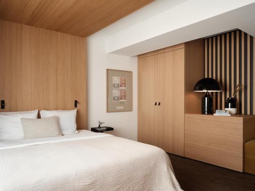 a bedroom with a large bed and a wooden cabinet at Bob W Münchner Freiheit in Munich