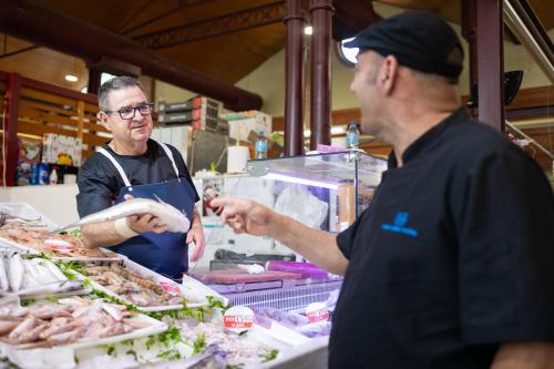 two men standing in a kitchen preparing food at Cullera Holiday in Cullera