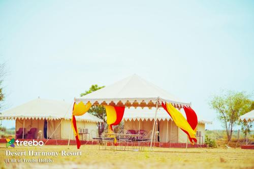 a tent with colorful flags in front of it at Treebo Desert Harmony Camp in Sām