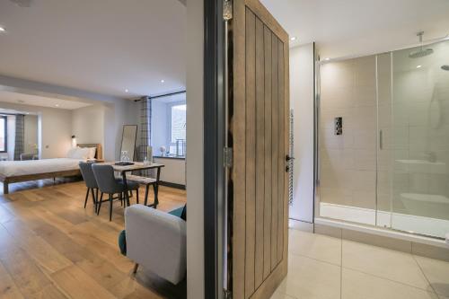 a bathroom with a shower and a table with chairs at Oban Bay Apartments in Oban