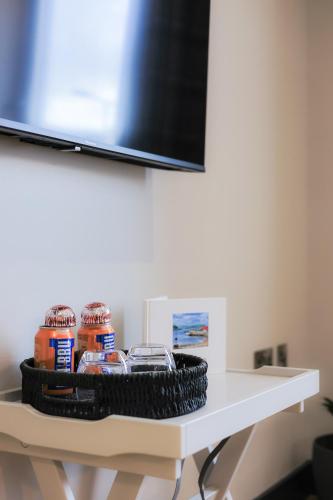 a white table with a tv on top at Oban Bay Apartments in Oban