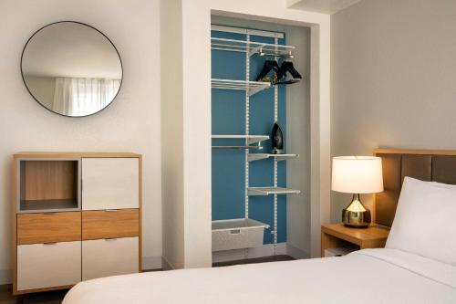 a bedroom with a bed and a mirror and a bathroom at TownePlace Suites Milpitas Silicon Valley in Milpitas