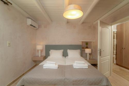 a bedroom with a bed with towels on it at Villa Petrohelidono in Petrokefálion