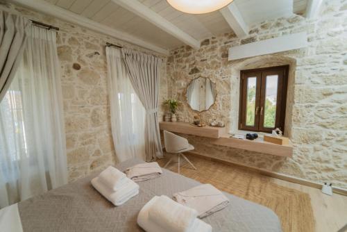 a bedroom with a large bed and a mirror at Villa Petrohelidono in Petrokefálion