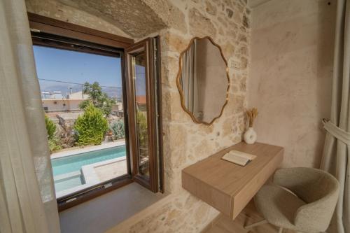 a room with a table and a mirror and a window at Villa Petrohelidono in Petrokefálion