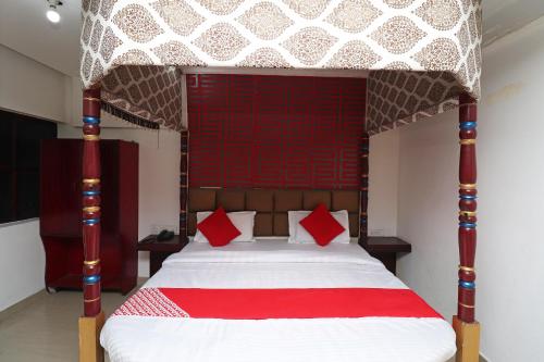 a bedroom with a large bed with red pillows at Hotel O D' Seasons Agra Cantt Railway Station in Tājganj