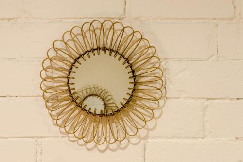 a gold mirror hanging on a brick wall at Novus Homes Barcelona Santa Eulalia in Hospitalet de Llobregat