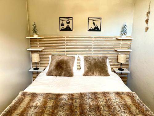 une chambre avec un grand lit avec deux oreillers dans l'établissement Appartement 35 m2 4p avec piscine chauffée la foux d Allos, à La Foux d'Allos