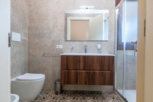 a bathroom with a toilet and a sink and a mirror at Gma Home Primo Piano in Pulsano