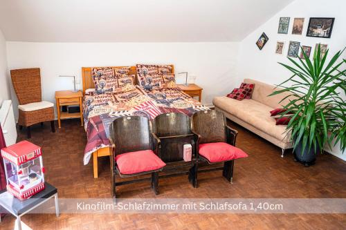 a bedroom with a bed and two chairs and a couch at Kinofilmwohnung mit großem Dachgarten im Gästehaus Graf-Schmelzer in Trittenheim