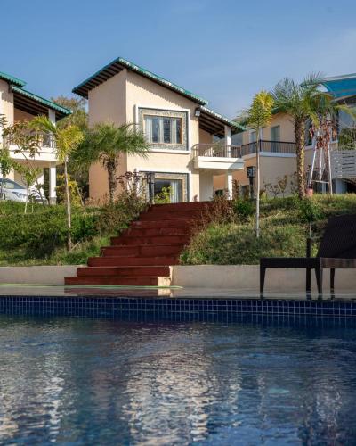 a house with stairs next to a body of water at Kudrat Resort-Jim Corbett in Kota Bāgh