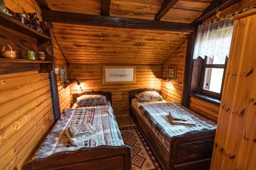 a bedroom with two beds in a log cabin at Villa Tara in Plaški