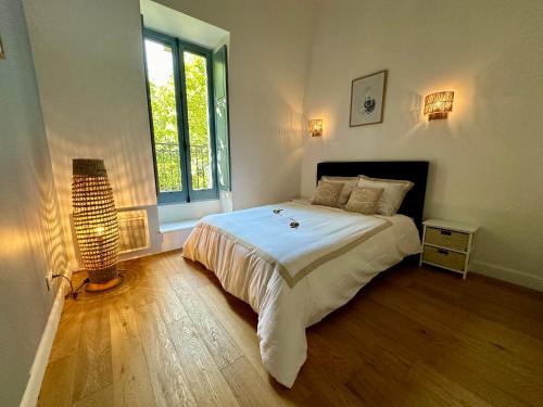 a bedroom with a large bed and a window at Appartement T2 Méditerranéen in Narbonne