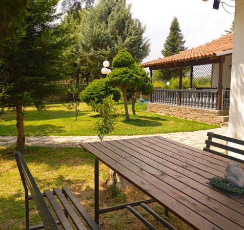a wooden picnic table and two chairs in a park at Oasis Cottage in Krepeni