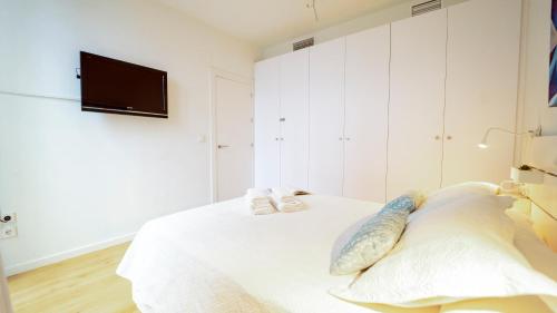 a white bedroom with a bed with shoes on it at DreamStay - Trinidad Apartamento in Granada