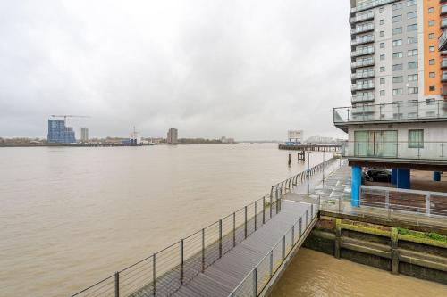 a dock with a building next to a body of water at Amazing River view 2 bedroom apartment, sleeps 6 , balcony and parking in London