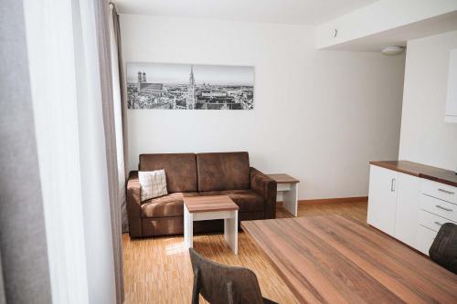 a living room with a couch and a table at Coffee Fellows Hotel München-Freiham in Munich