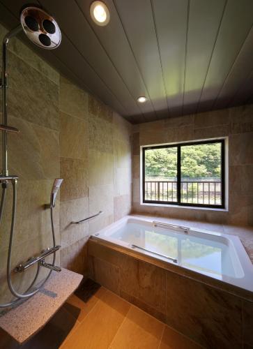 a large bathroom with a tub and a window at Asaya in Nikko