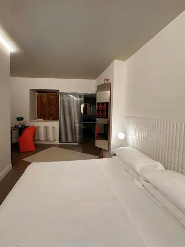 a bedroom with a large white bed in a room at Ginevra Boutique Rooms - Palazzo Leosini - Residenze D'Epoca in LʼAquila
