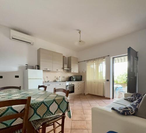 a kitchen and living room with a table and a couch at La casa tra gli ulivi di Fonte Nuova in Fonte Nuova