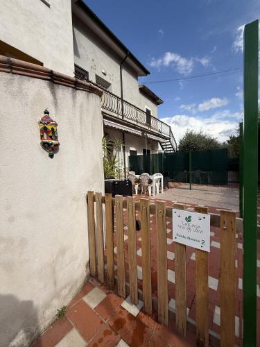 a fence with a sign on the side of a house at La casa tra gli ulivi di Fonte Nuova in Fonte Nuova