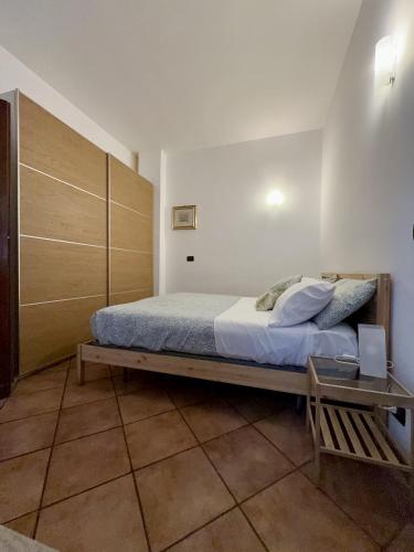 a bedroom with a bed and a wooden cabinet at La casa tra gli ulivi di Fonte Nuova in Fonte Nuova