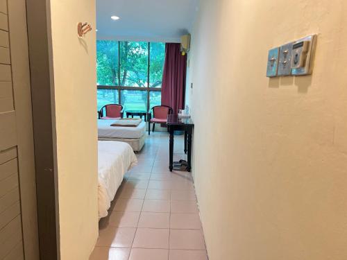 a room with two beds and a desk and a table at VIP 房间a in Mukah
