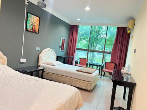 a hotel room with two beds and a table and chairs at VIP 房间a in Mukah